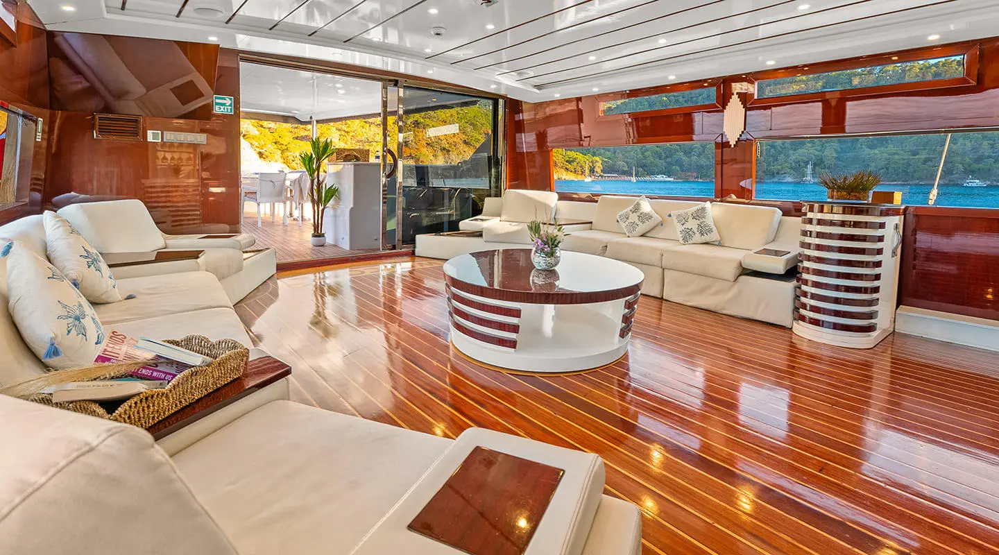 Luxurious white sofa seating in a wooden yacht saloon with a round coffee table