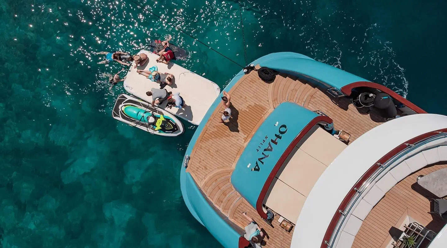 Top-down view of a brown deck yacht Ohana with blue accents at sea