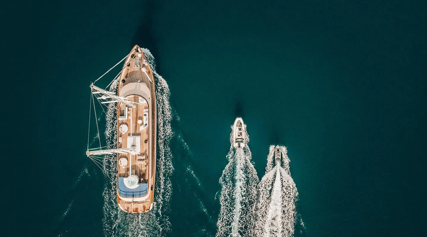 Aerial view of Maxita yacht with wooden deck sailing in open sea