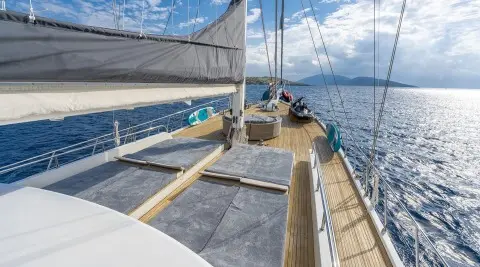 Sun deck of gulet Lucky You with people lounging on wooden seating under canopy