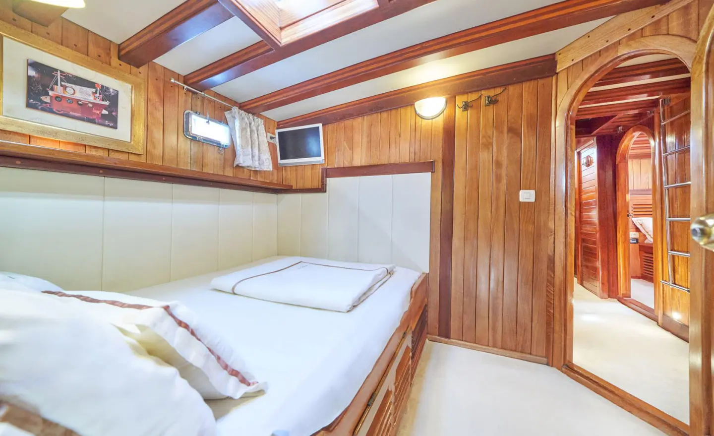 Luxurious Libra yacht charter cabin with wooden paneling and two beds