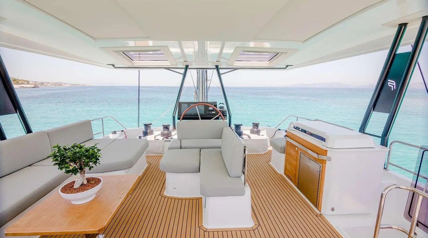 Astoria yacht at sunset, teak deck, white seating, stern view on calm sea