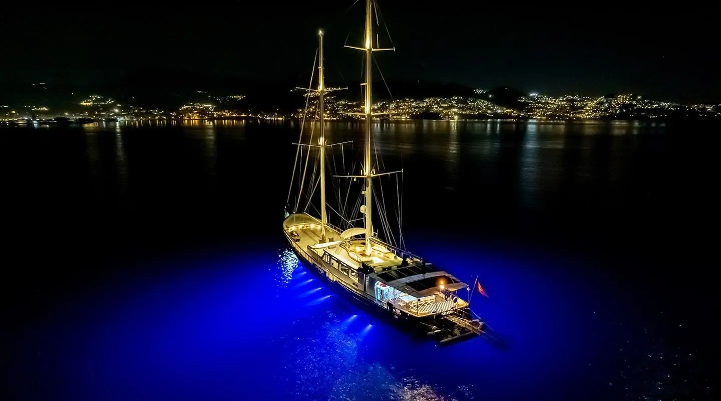 Double Eagle luxury yacht anchored at night with blue-lit water around