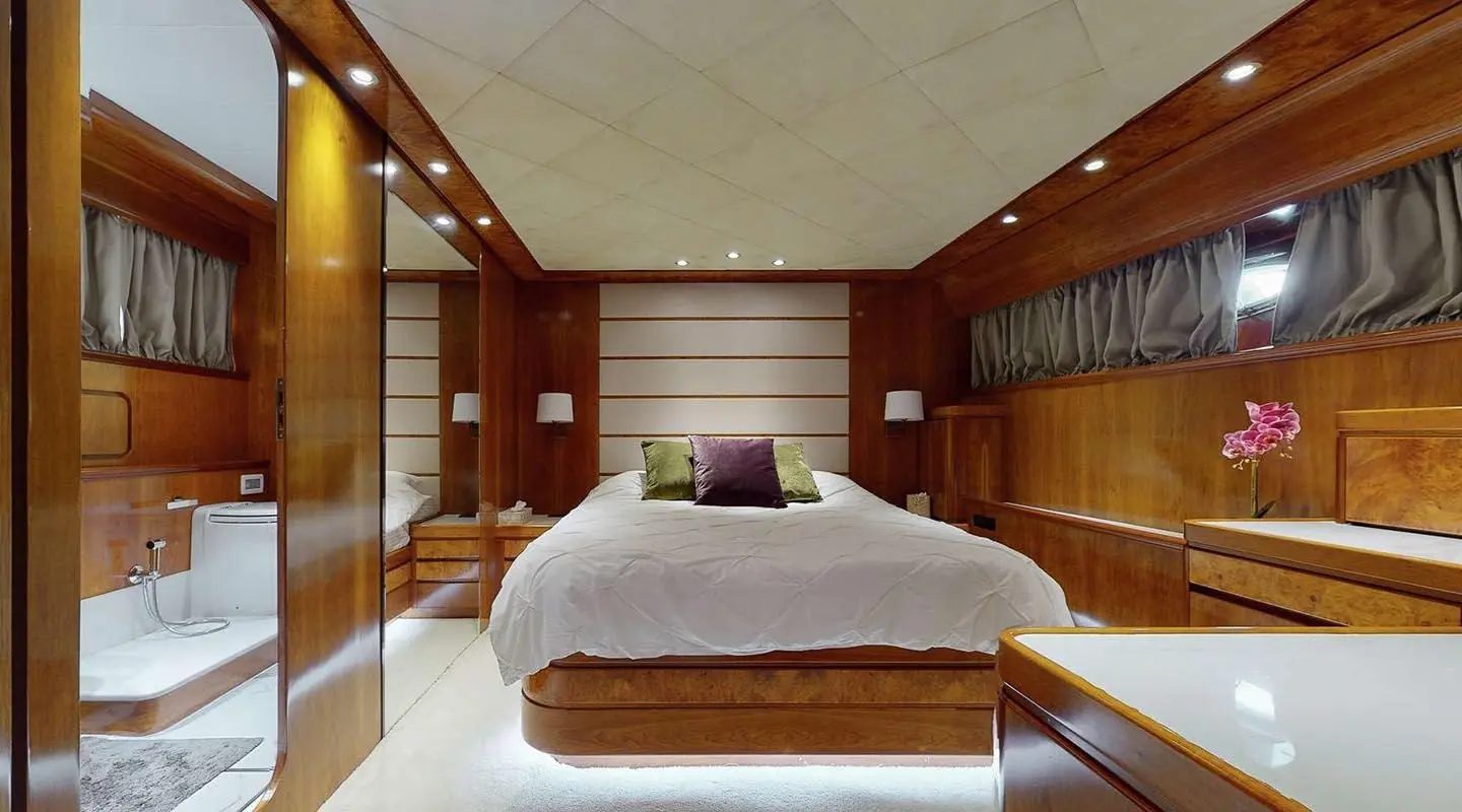 Interior bright cabin aboard Lady Natassa yacht, double bed with brown headboard