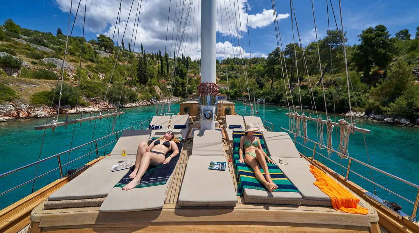 Two sun loungers on a gulet Libra deck with a serene pool and blue water