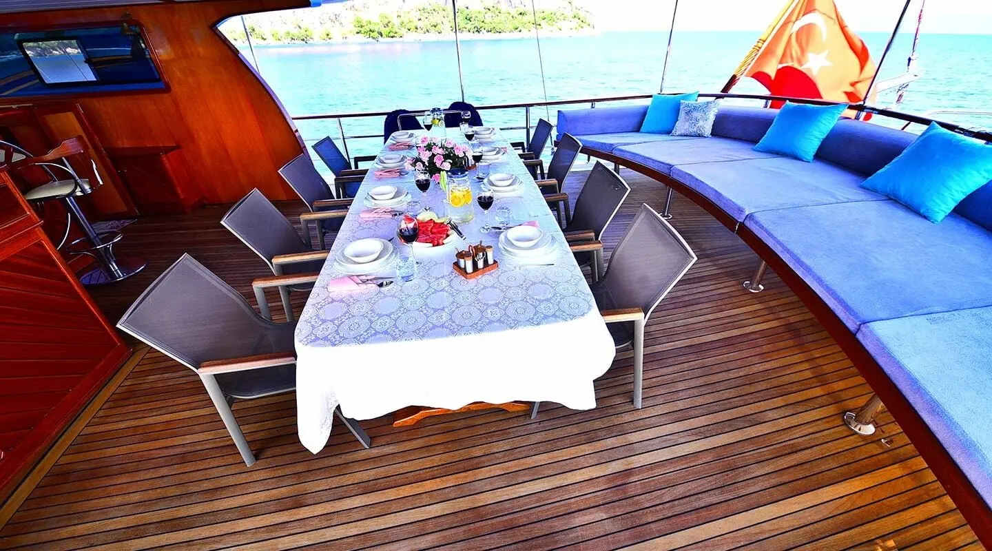 Gulet Maya aft deck with dining table set for guests and sunshade