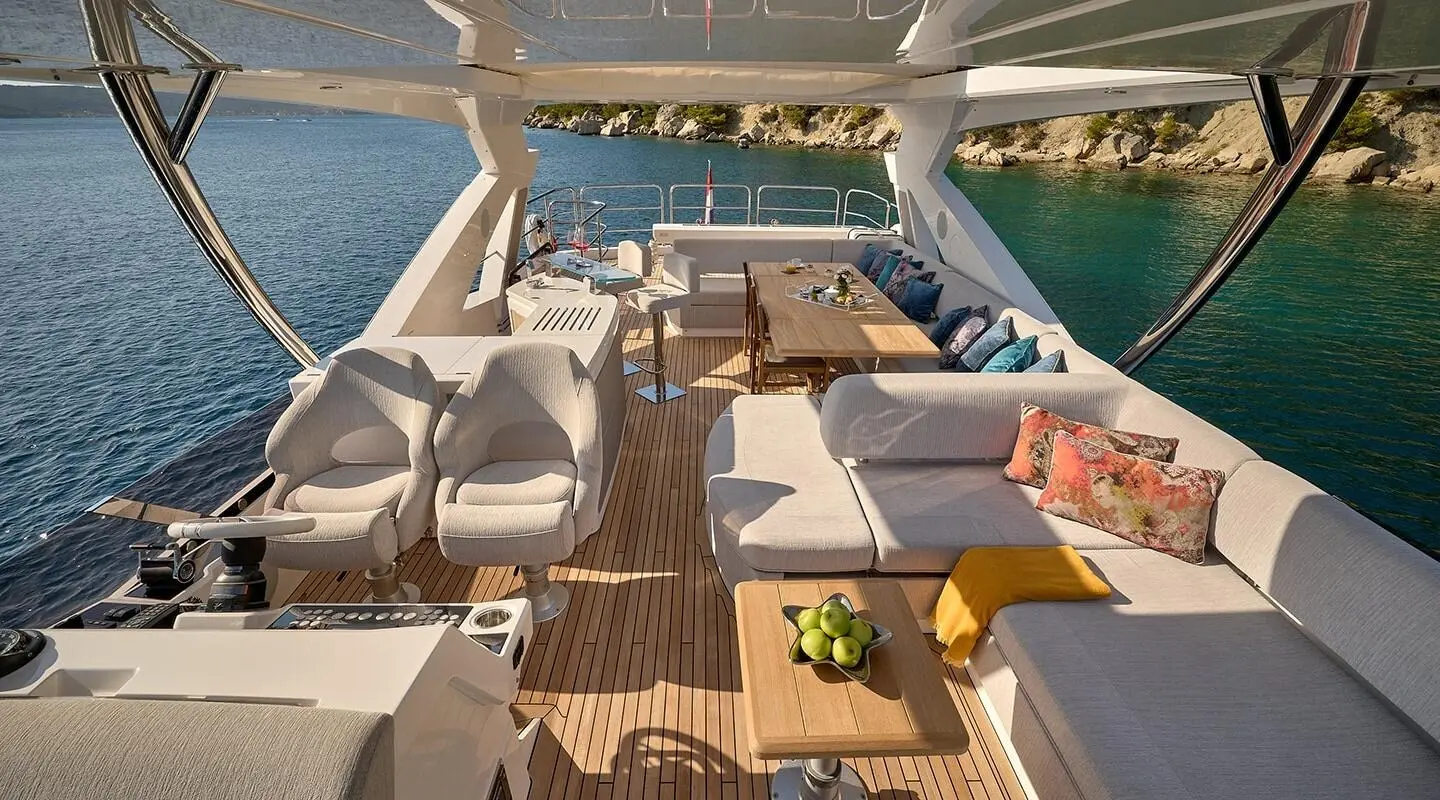 Perspective view from yacht deck with seating, table, and water beyond