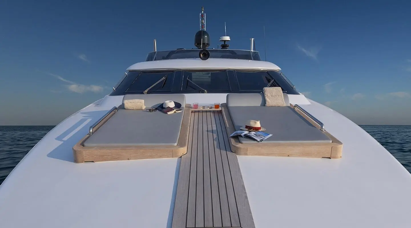 Project Steel yacht bow sun loungers on teak deck with sea horizon