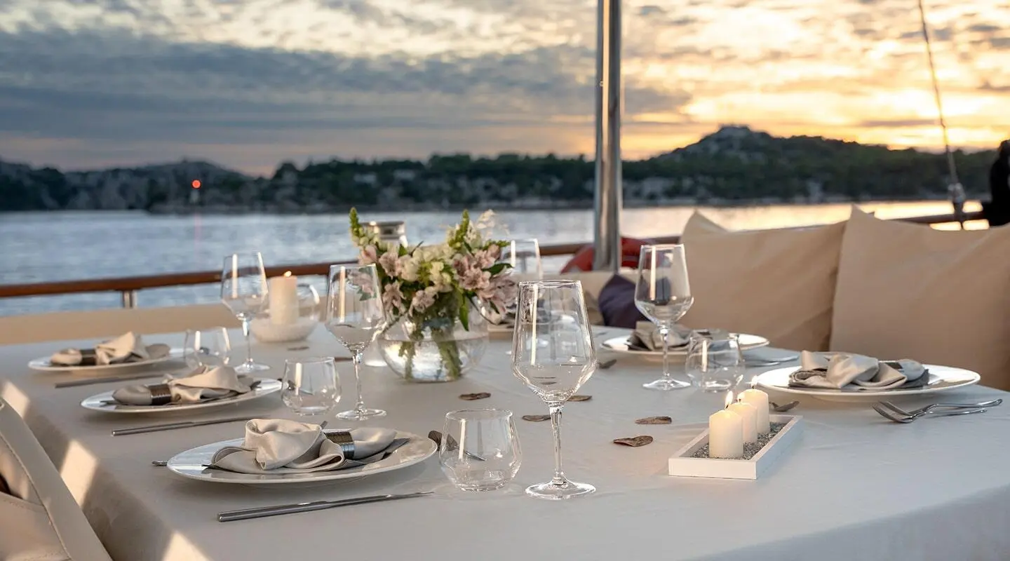 Elegant table set for dining on Alessandro I yacht, wine glasses and flowers