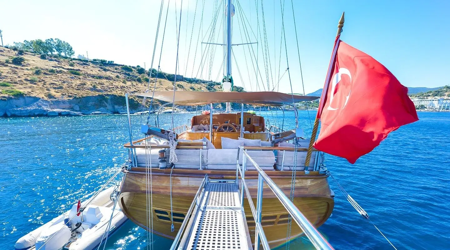 View from the deck of Lady Christa yacht as a gulet with masts at sunset harbor