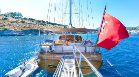 View from the deck of Lady Christa yacht as a gulet with masts at sunset harbor