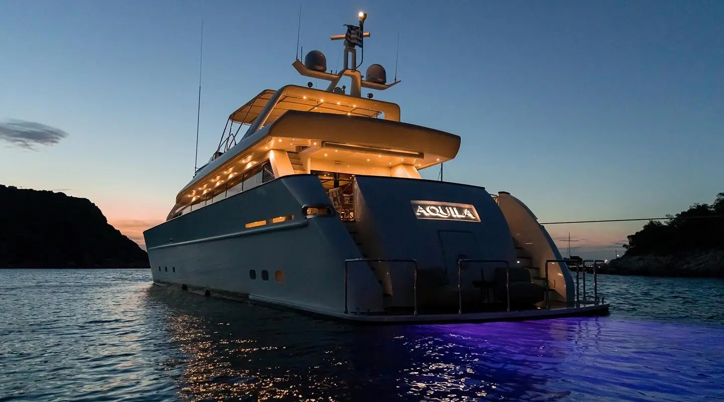 Aquila luxury yacht at sunset, bow forward, calm sea and clear sky