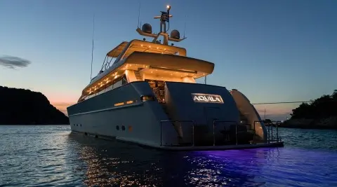 Aquila luxury yacht at sunset, bow forward, calm sea and clear sky