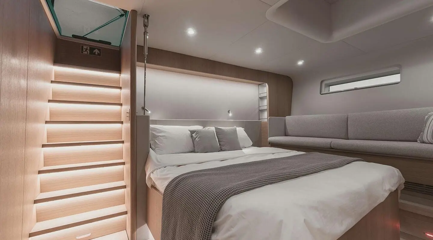 Nadamas motor yacht interior with double bed, neutral tones, porthole light
