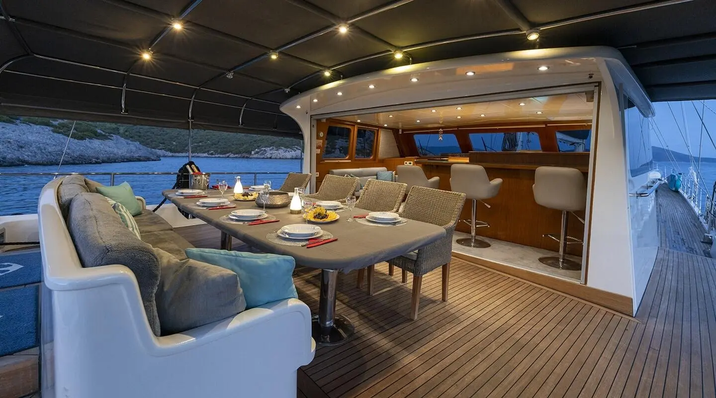 Luxurious yacht Lucky You deck with seating, table, and sunset sea view