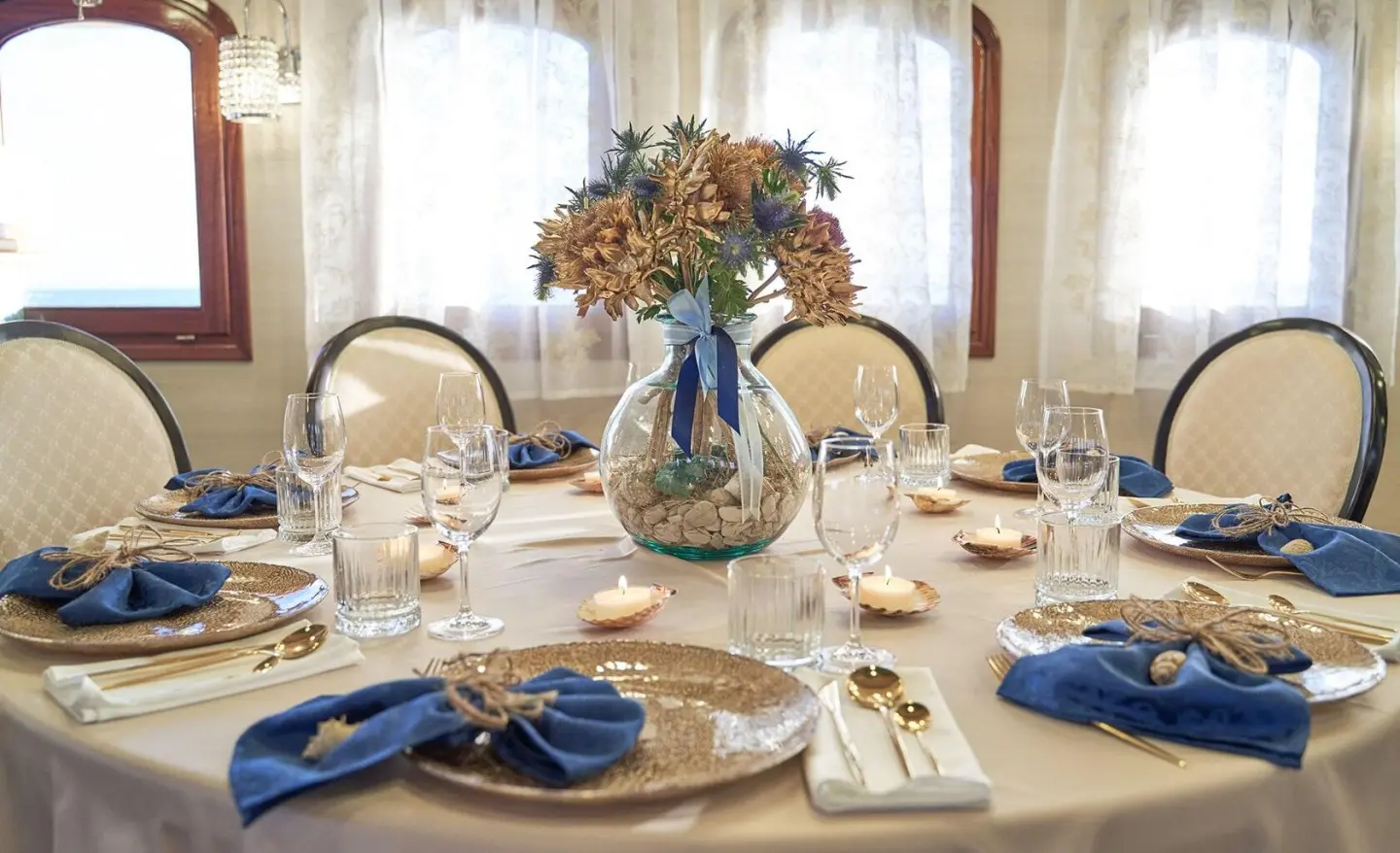Dining table on Casablanca yacht with floral centerpiece and blue napkins