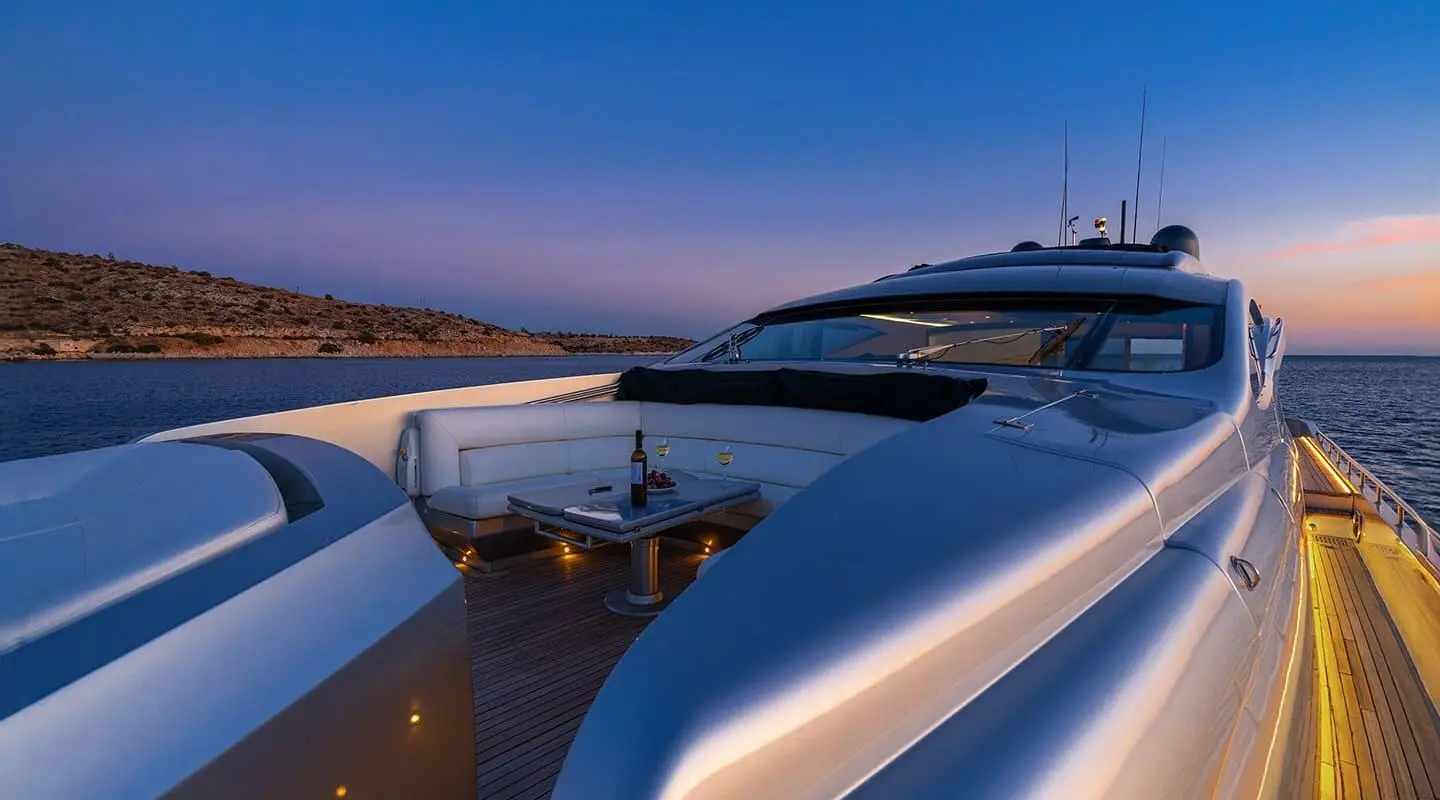 One luxury motor yacht at dusk with white exterior and spacious aft seating on deck.