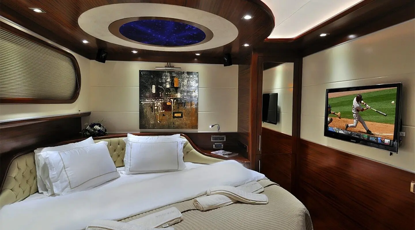 The Dolce Mare luxury yacht bedroom with bed, pillows, and wood paneling