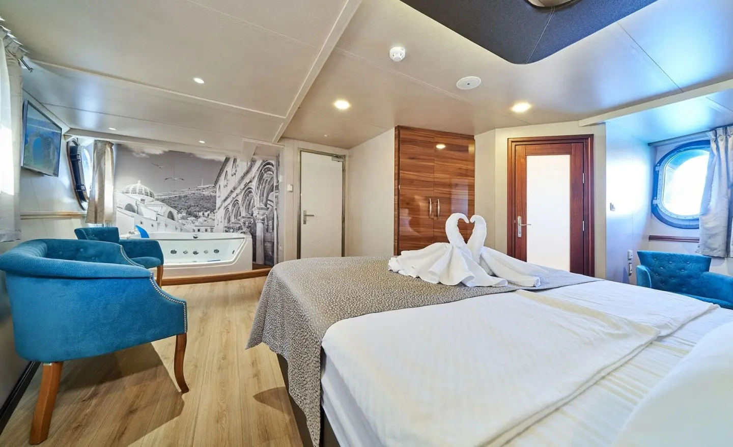 Casablanca yacht cabin: two single beds, white linens, wood accents, seating area