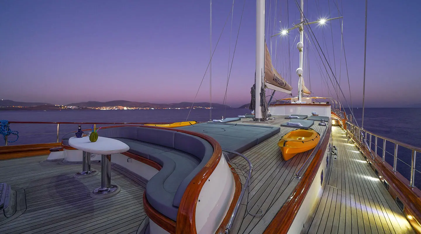 La Bella Vita yacht deck at sunset with polished wood and cushioned seating