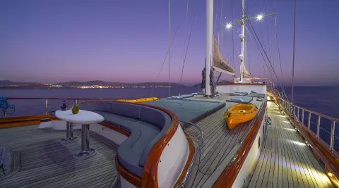 La Bella Vita yacht deck at sunset with polished wood and cushioned seating