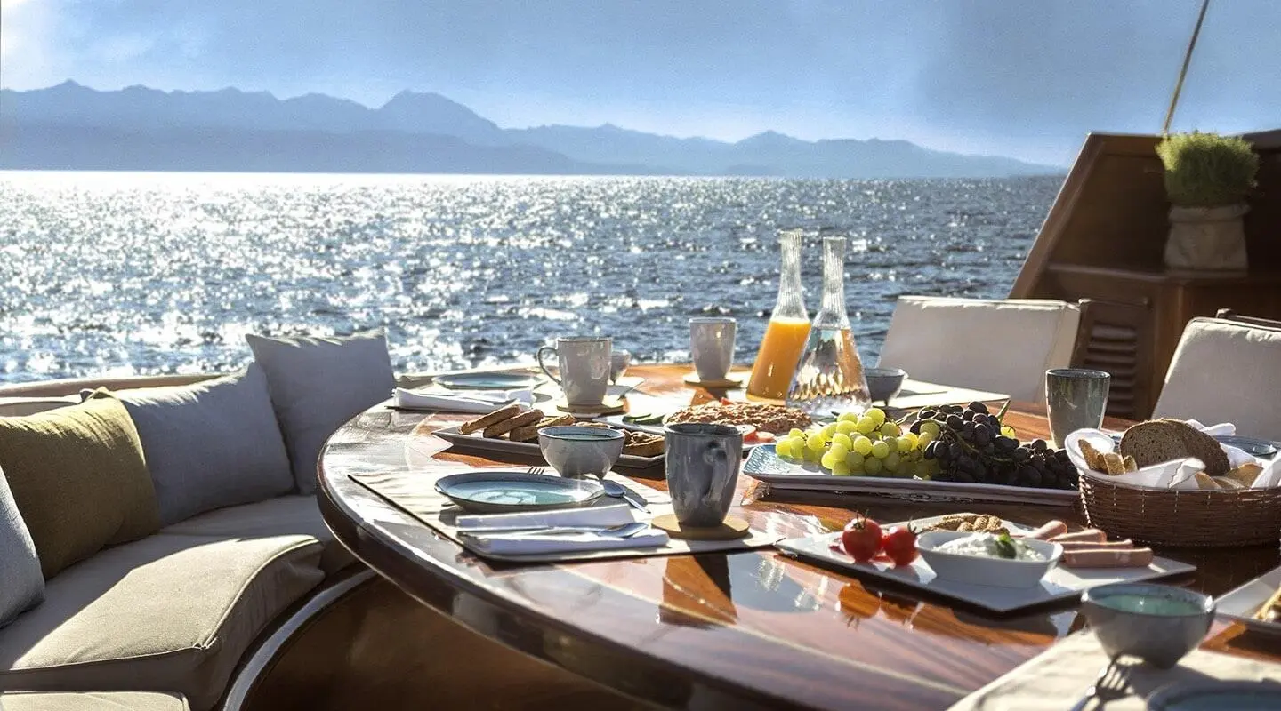 Entre Cielos yacht table set for dinner on deck at sunset