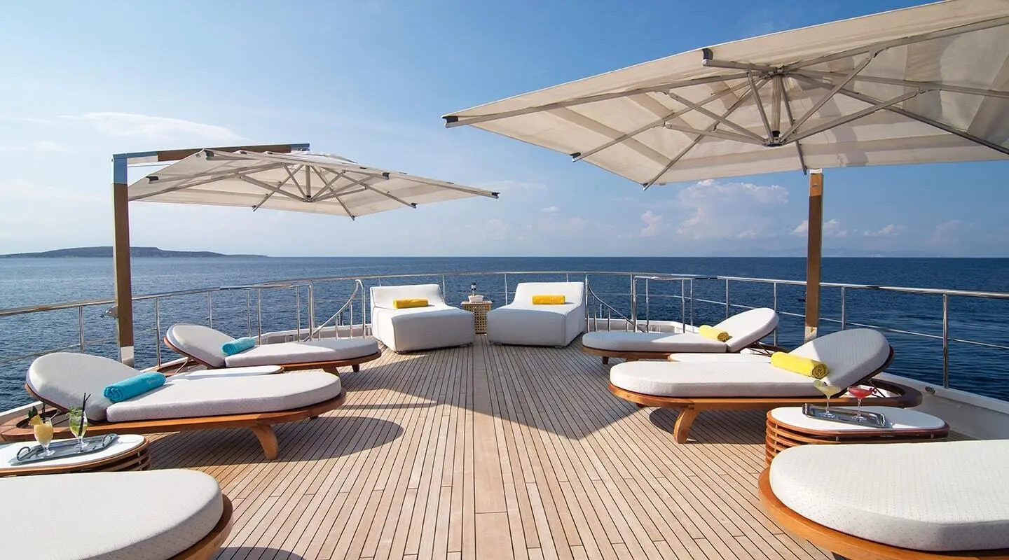 O'Natalina yacht sun deck with lounge chairs under umbrellas and sea view