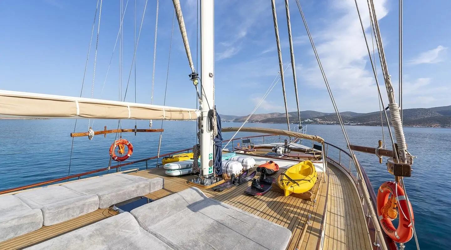 Yacht deck of Gozdem The One with sails, sunlit teak, and ocean view