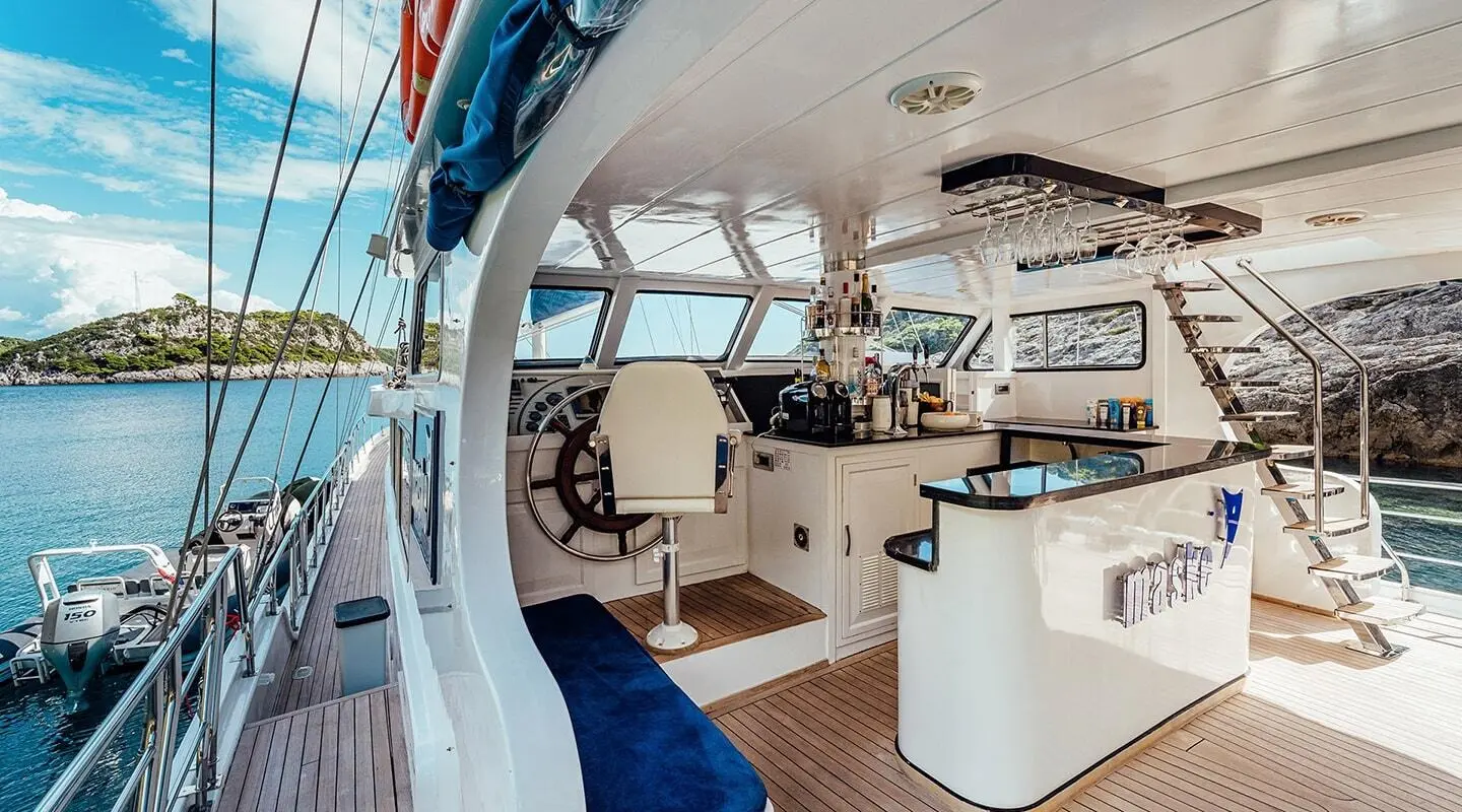 A gulet Maske aft deck with open seating, helm station, and sunny overhead