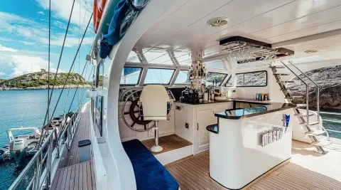 A gulet Maske aft deck with open seating, helm station, and sunny overhead