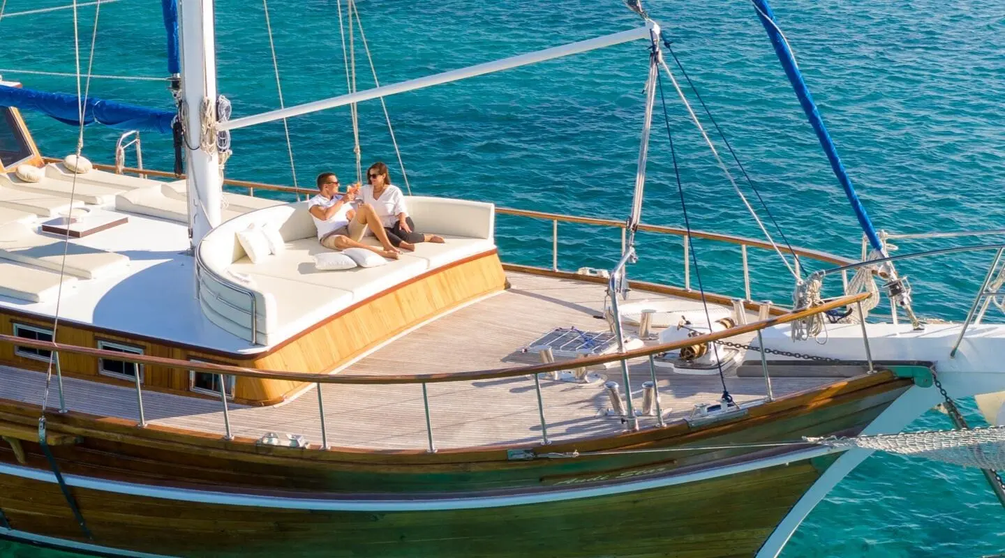 Andi Star yacht deck at sunset with lounging area and railings over calm blue sea
