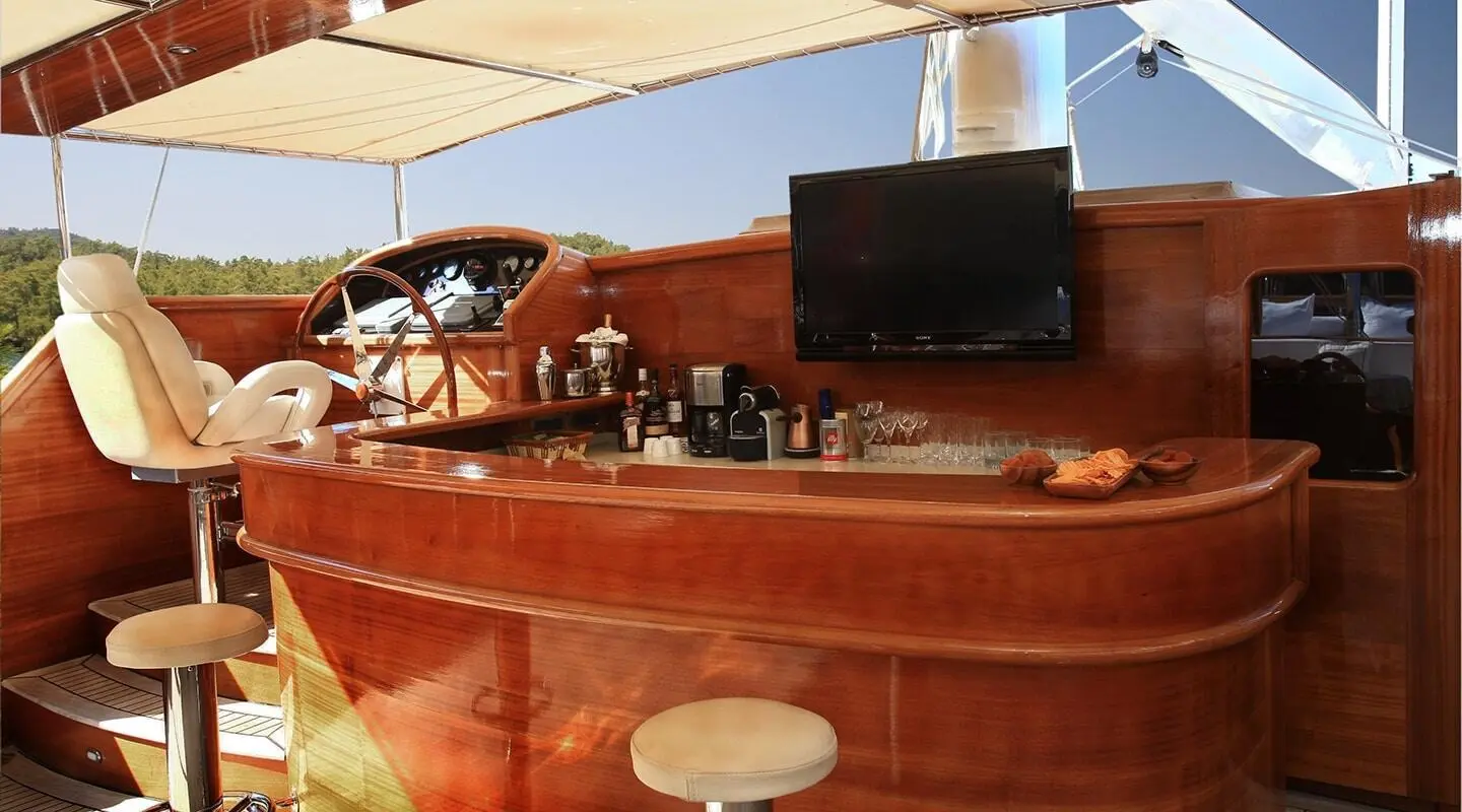 Kaya Guneri 5 yacht bar on deck at sunset with wood finish and seating