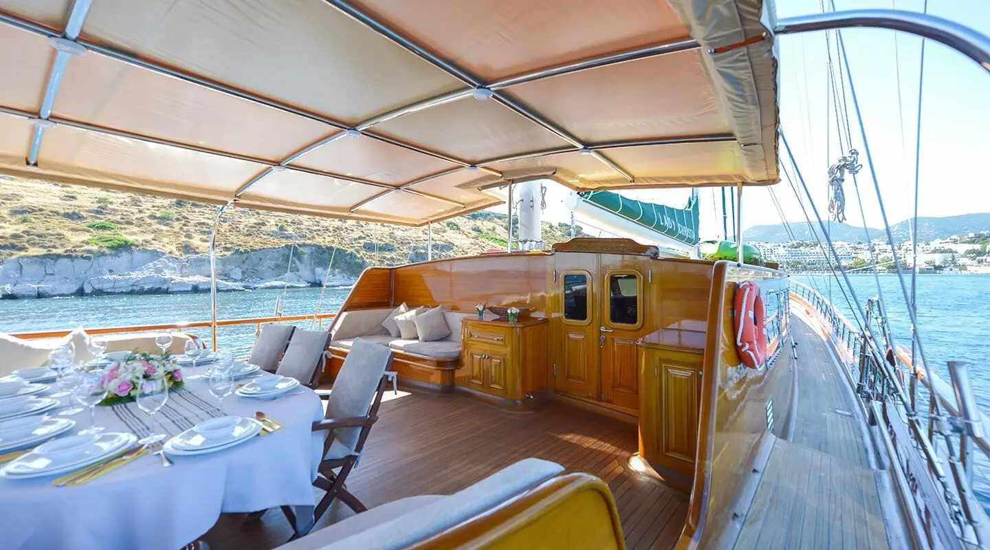 Sunset-lit deck of Lady Christa yacht with seating, helm, and navigation area