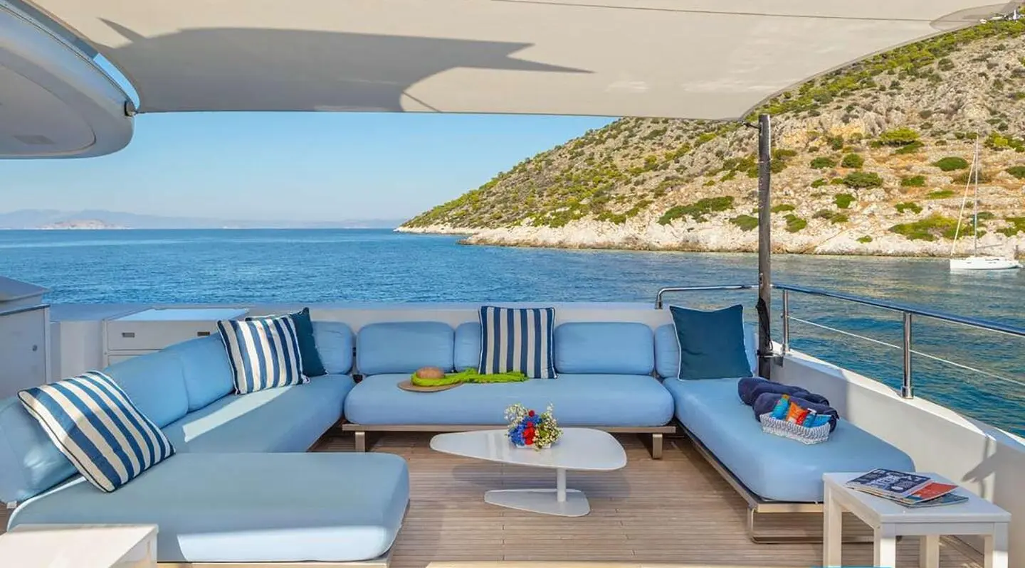 Open aft deck with blue cushioned seating and ocean view