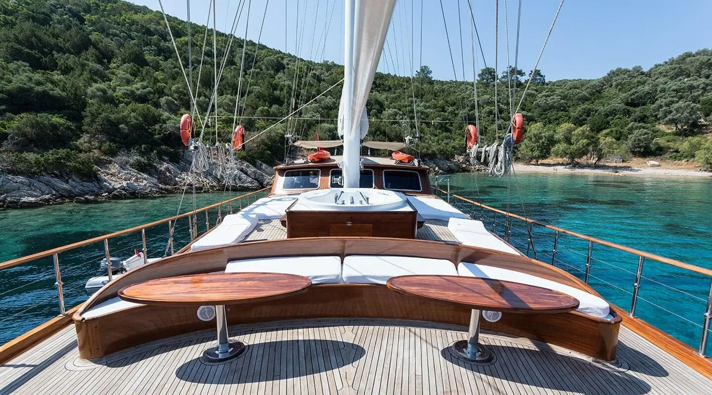 Grace 1 yacht stern deck with wooden rail, seating, and calm water