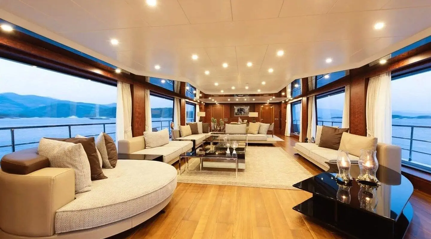 Ocean Breeze yacht interior lounge with wooden floor, seating, and warm lighting