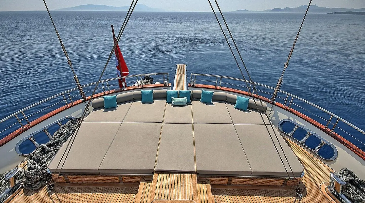 Meira yacht deck view facing calm sea at sunset, seating, railings, and water horizon
