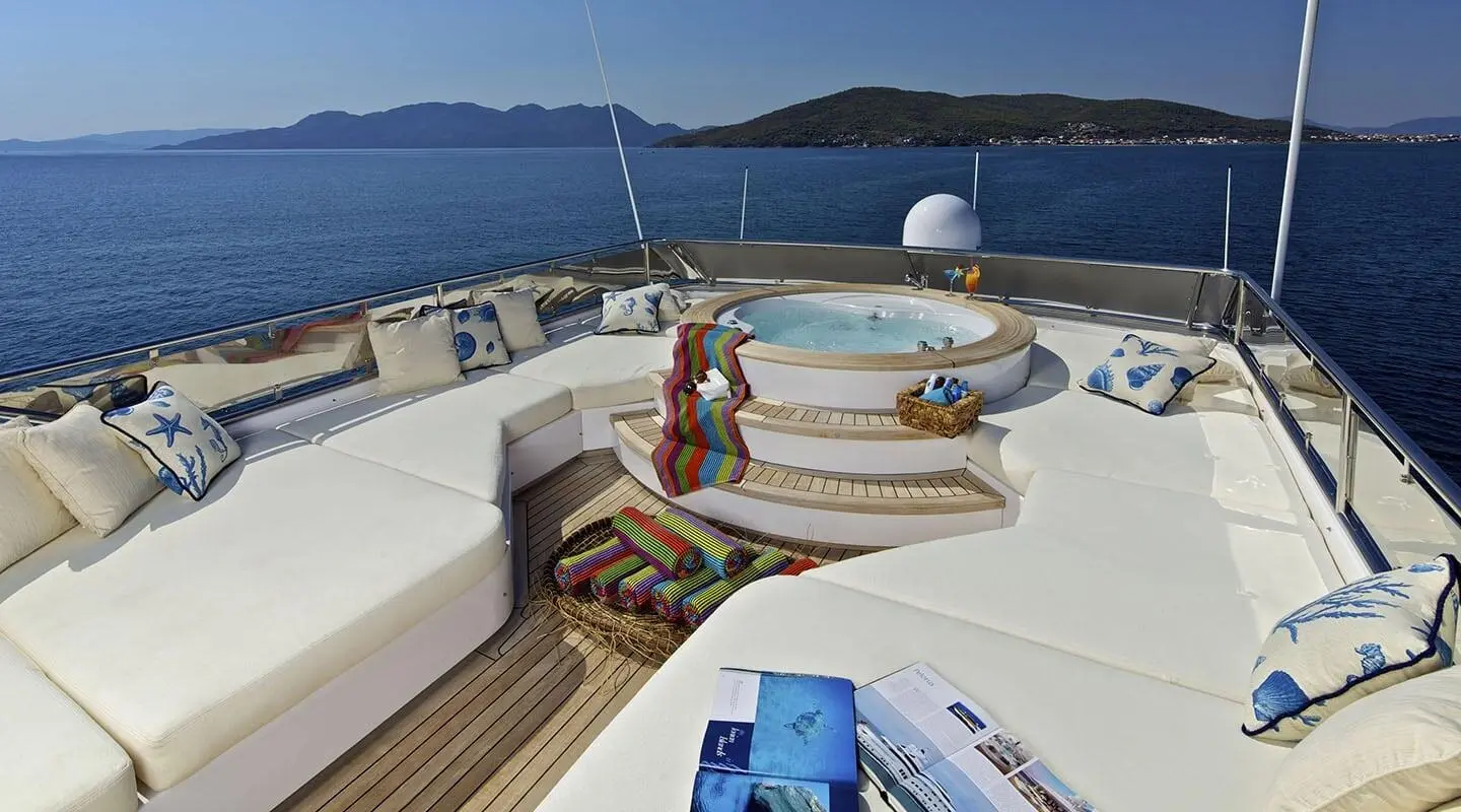 Sun deck of O'Rion yacht with people relaxing near loungers and stairs