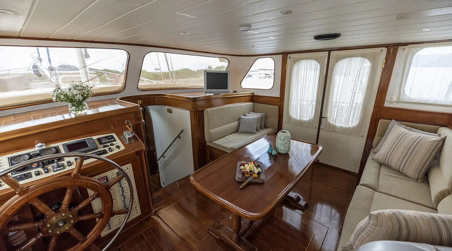 Interior of a gulet yacht Faralya saloon with wooden furniture and windows