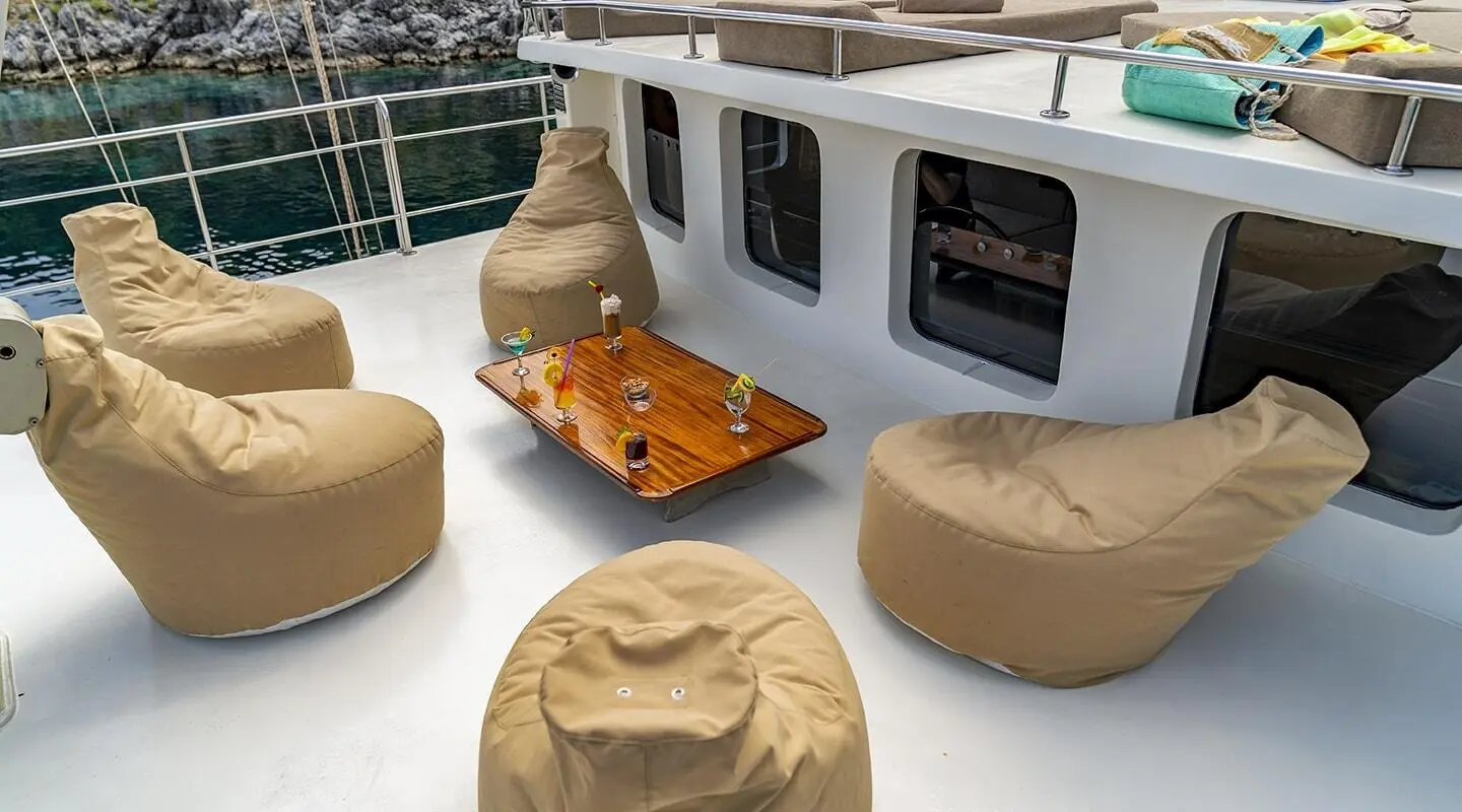 Tersane 8 yacht deck lounge with beige bean bag seats and wooden cocktail table