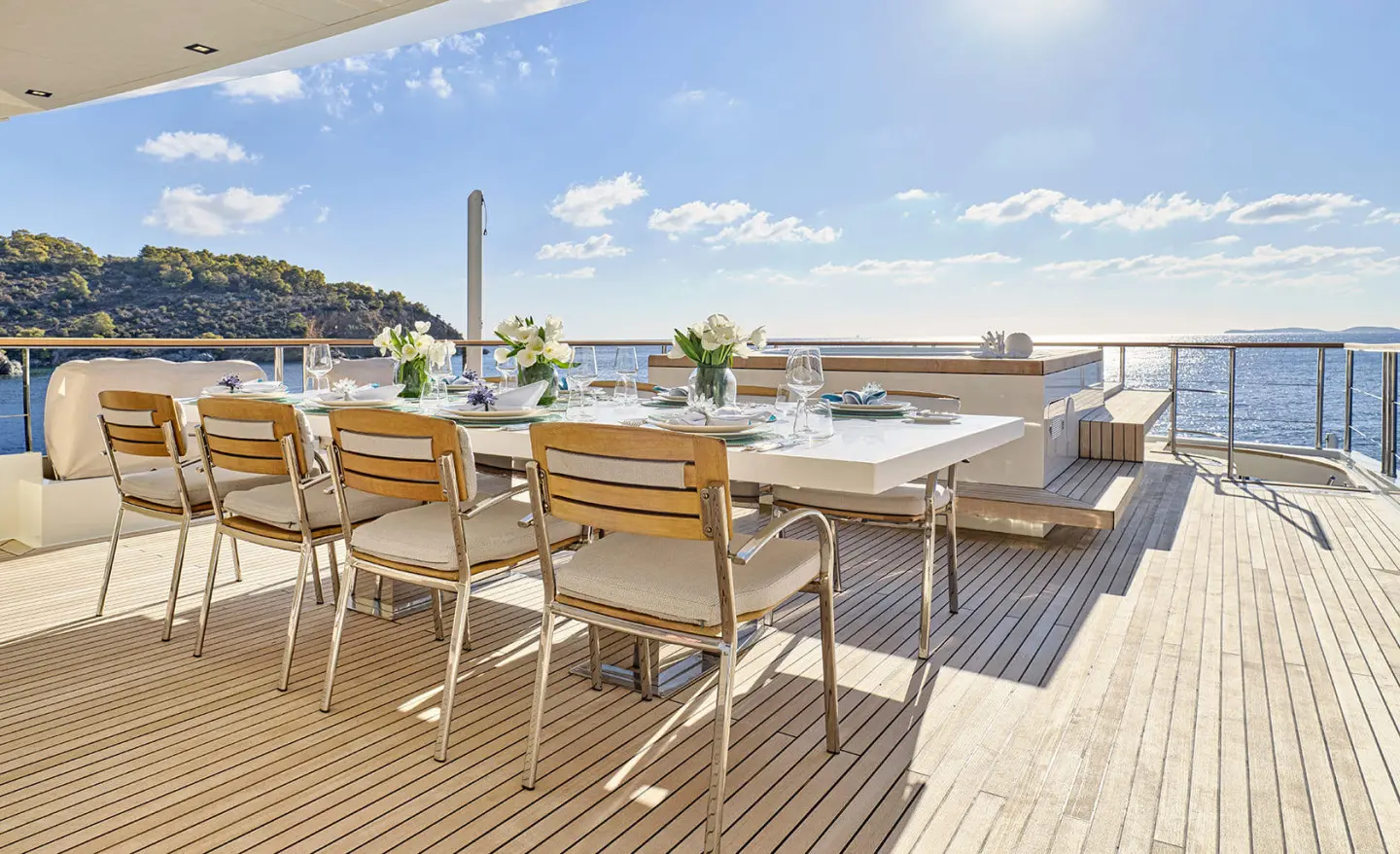 La Pellegrina 1 yacht dining area on deck with wooden chairs at sunset