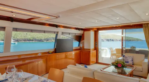 Lidia yacht interior: sunlit lounge with beige seating, wooden accents, large windows