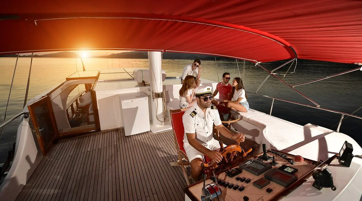 Blu Dream gulet yacht with people on a shaded deck under a red canopy