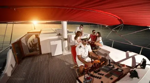 Blu Dream gulet yacht with people on a shaded deck under a red canopy