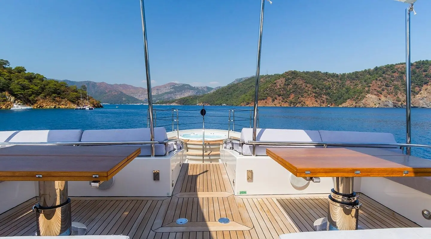 Open deck lounge with wooden tables, aft view of Takara One yacht