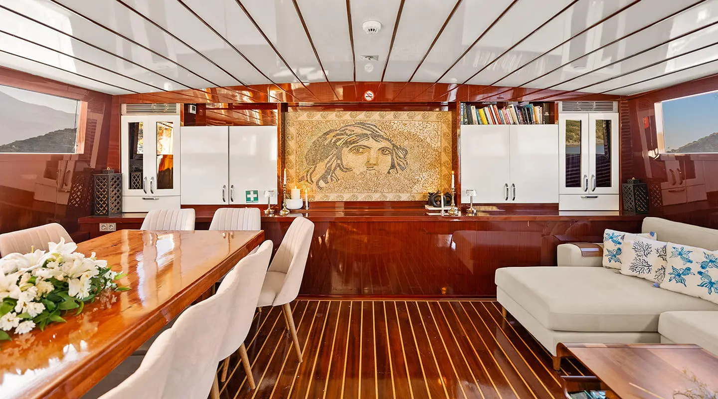 Interior deck of Esma Sultan gulet with polished wooden flooring and steering helm