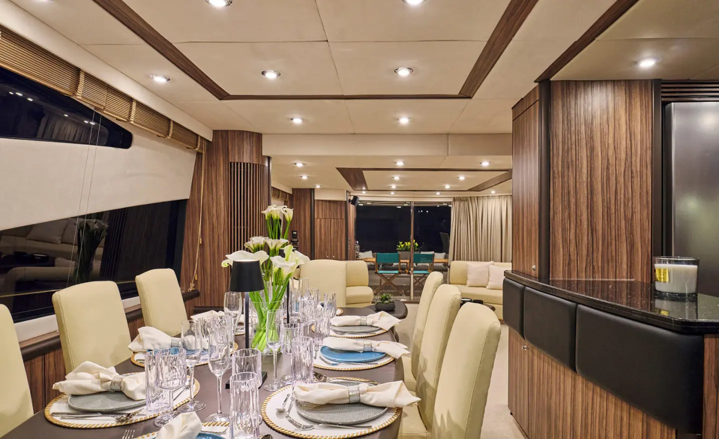 Interior dining area on M Five yacht with table setting and beige seating