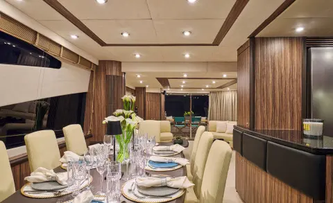 Interior dining area on M Five yacht with table setting and beige seating