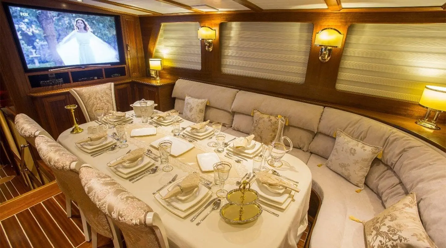 Table set for dining on a gulet yacht with white linens and gold accents