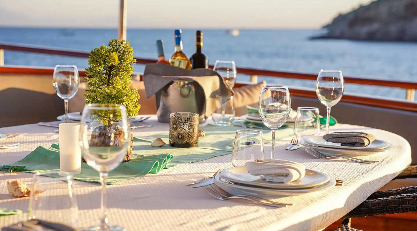 La Bella Vita luxury gulet at sunset with dining setup on deck